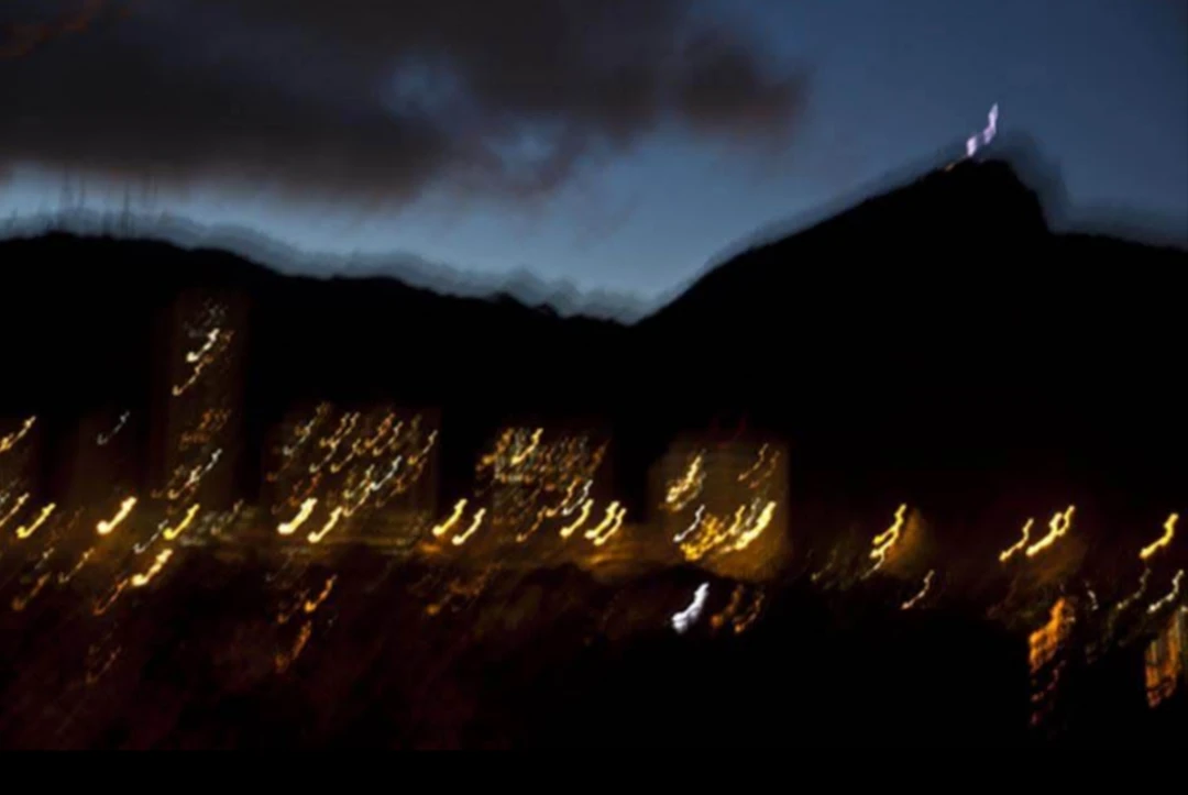 Paisagem noturna com montanhas e luzes em movimento
