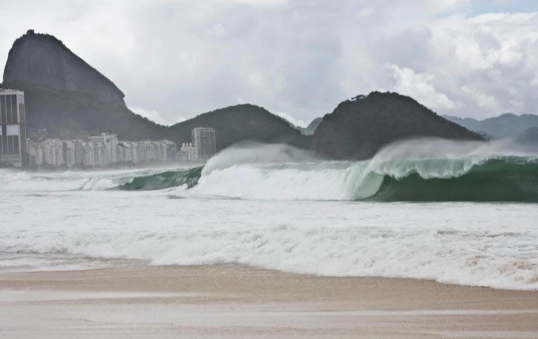 Ondas do mar diante de montanhas em preto e branco