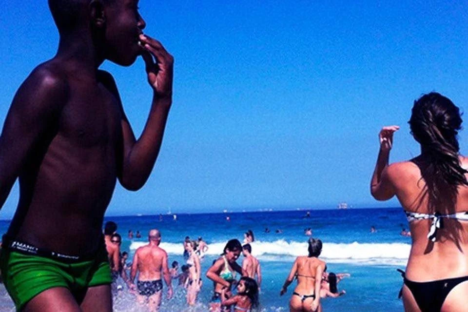 Pessoas na praia sob um céu azul intenso