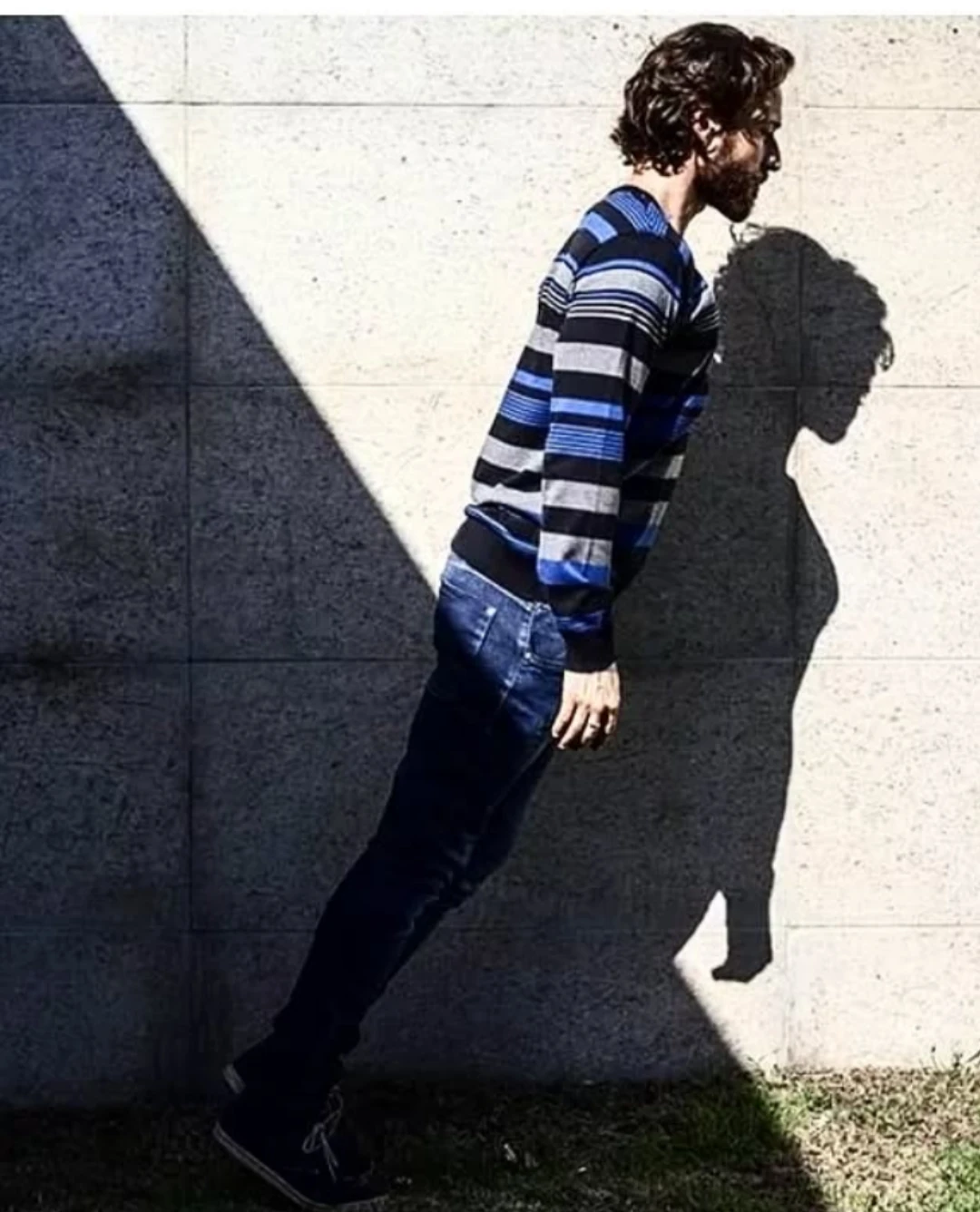 Figura de roupa listrada e sua sombra sobre a parede