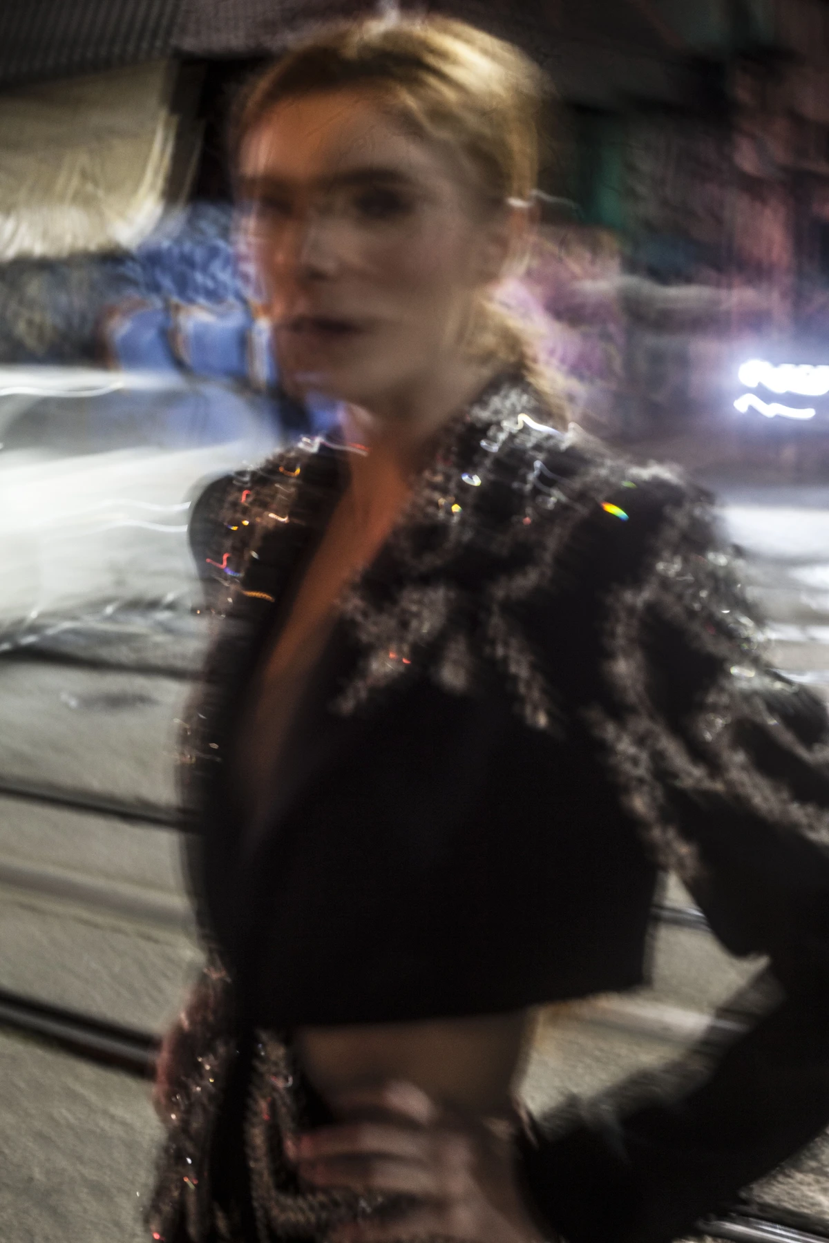 Retrato noturno com roupa escura e as luzes da rua ao fundo